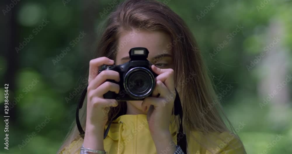 4K Portrait. Young Girl with Camera in a Forest.Young Student taking photographs in Yellow Rain coat and Backpack. Gap Year Traveller with Blonde Hair,Woman in a British National Trust Park 4K Portrait. Young Girl with Camera in a Forest.Young Student taking photographs in Yellow Rain coat and Backpack. Gap Year Traveller with Blonde Hair,Woman in a British National Trust Park