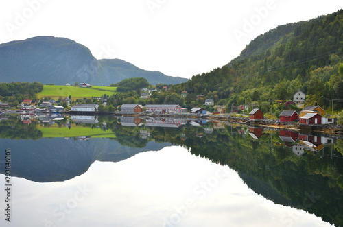 Mountains and Small Town Reflection on Calm Water Fjord in Norway on Summer