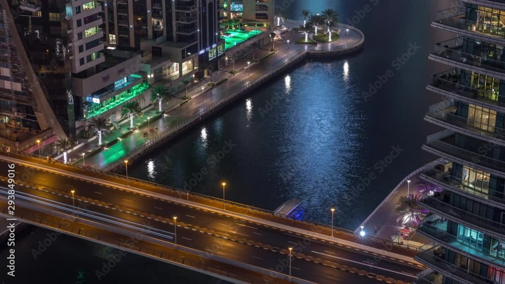 Waterfront promenade with traffic on a bridge in Dubai Marina aerial night timelapse. Boats and yachts floating on canal. Dubai, United Arab Emirates Waterfront promenade with traffic on a bridge in Dubai Marina aerial night timelapse. Boats and yachts floating on canal. Dubai, United Arab Emirates