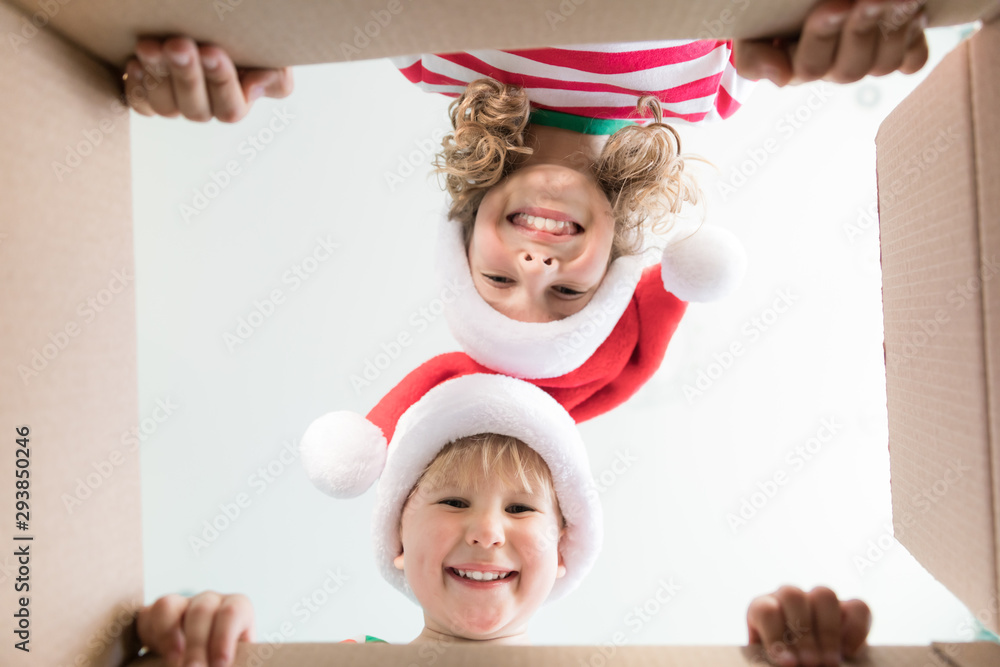 Wall Mural Surprised children unpack Christmas gift box