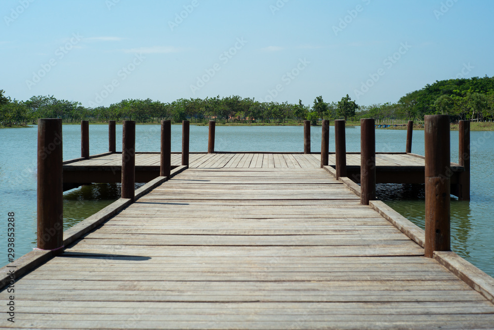 Wooden bridge into the lake with trees and horizontal line in background