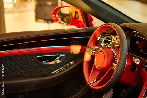 Red luxury car Interior. Steering wheel, shift lever and dashboard. Shallow doff © sarymsakov.com