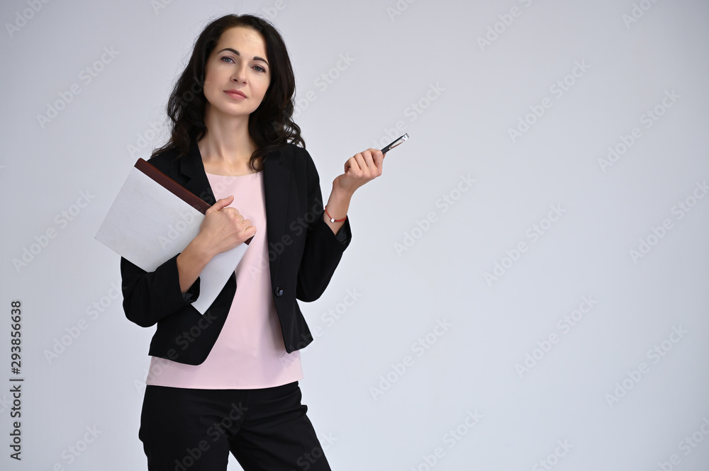 Close-up portrait of an adult pretty brunette woman in a business suit with magnificent black hair on a white background in studio. Beauty, model posing. Close-up portrait of an adult pretty brunette woman in a business suit with magnificent black hair on a white background in studio. Beauty, model posing.