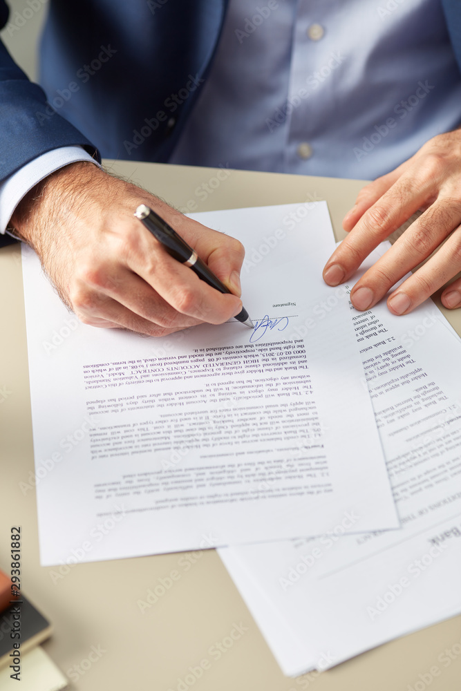 Man putting personal signature on paper Man putting personal signature on paper