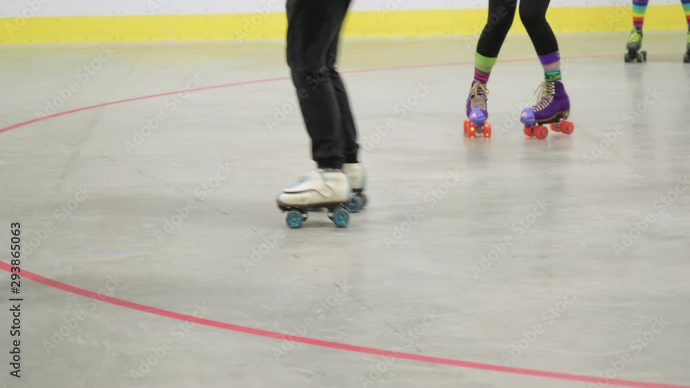 View Of Lower Half Of Adult Practising Skating Moves On Indoor Skate Rink View Of Lower Half Of Adult Practising Skating Moves On Indoor Skate Rink