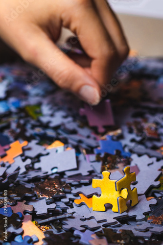 Two yellow puzzles looking at hand reaching for other puzzles. The concept of taking part in recruitment.