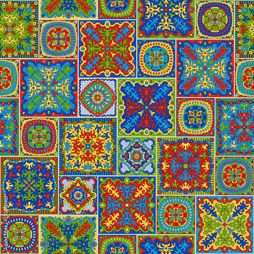 Seamless patchwork pattern of bright colored mosaic tiles with hand drawn geometrical and floral ornaments in Talavera majolica ceramic style. Wallpaper décor, pop art batik print, wrapping paper