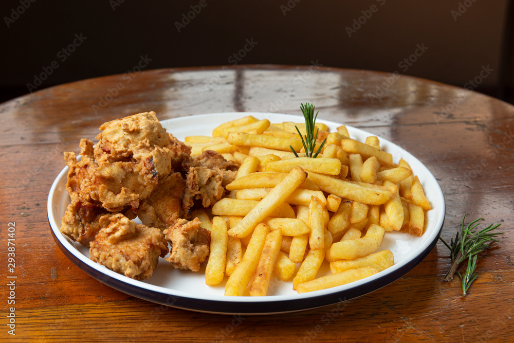 Fried Chicken. Fried chicken nuggets with french fries. Chicharron de pollo. Wooden background. Fried Chicken. Fried chicken nuggets with french fries. Chicharron de pollo. Wooden background.