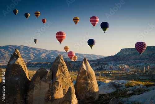 Hot air balloons flying over the karst landscape at sunrise, Goreme, Cappadocia, Turkey