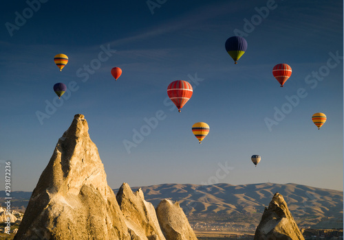 Hot air balloons flying over Goreme valley at sunrise, Cappadocia, Turkey