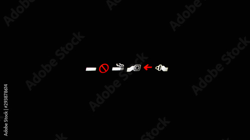 luminous placard fasten seat belts and a ban on smoking in an airplane on a black background