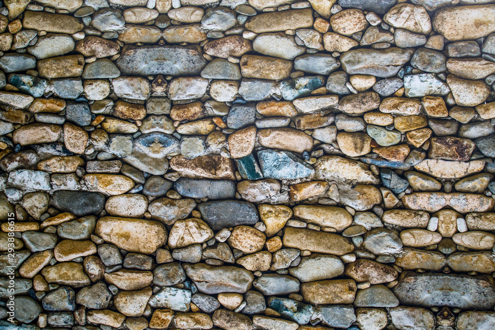 View of a wall of stones of irregular shapes, Backgrounds textures for graphic design. Wallpaper Abstract illustration of a natural stone. View of a wall of stones of irregular shapes, Backgrounds textures for graphic design. Wallpaper Abstract illustration of a natural stone.