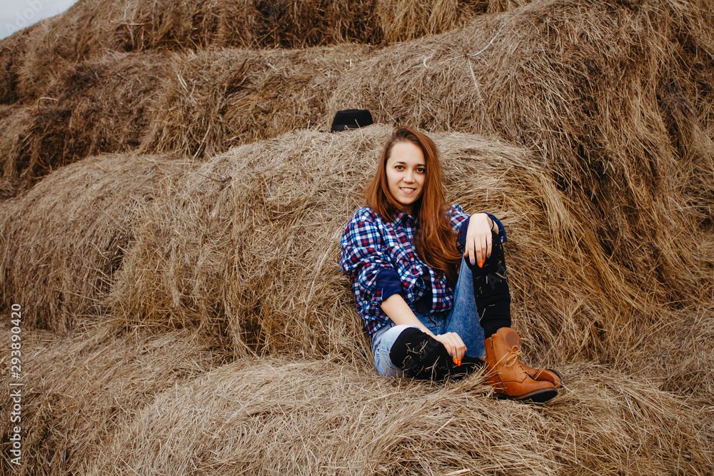 A young woman sitting in the hay looking into the frame close-up. A young woman sitting in the hay looking into the frame close-up.