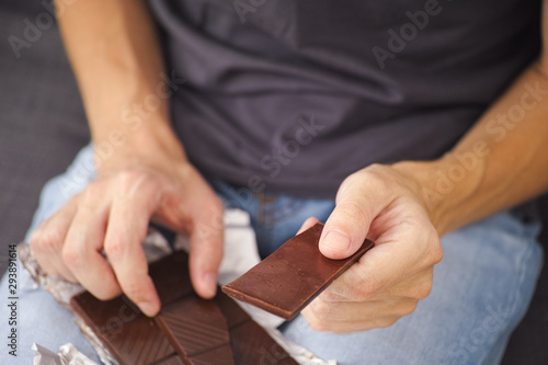 Man holding dark chocolate in his hands