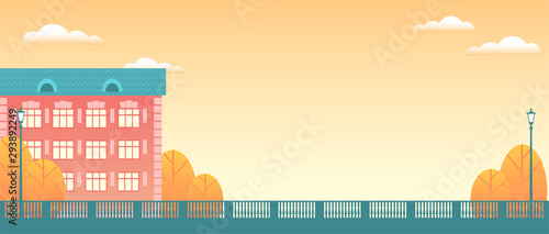 Background of the autumn city. Residential building, yellow trees, patterned fencing, clouds in the sky. Vector flat illustration in the form of a banner.