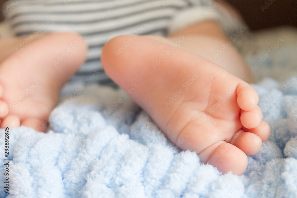  newborn baby legs in baby cot, the concept of motherhood, child care