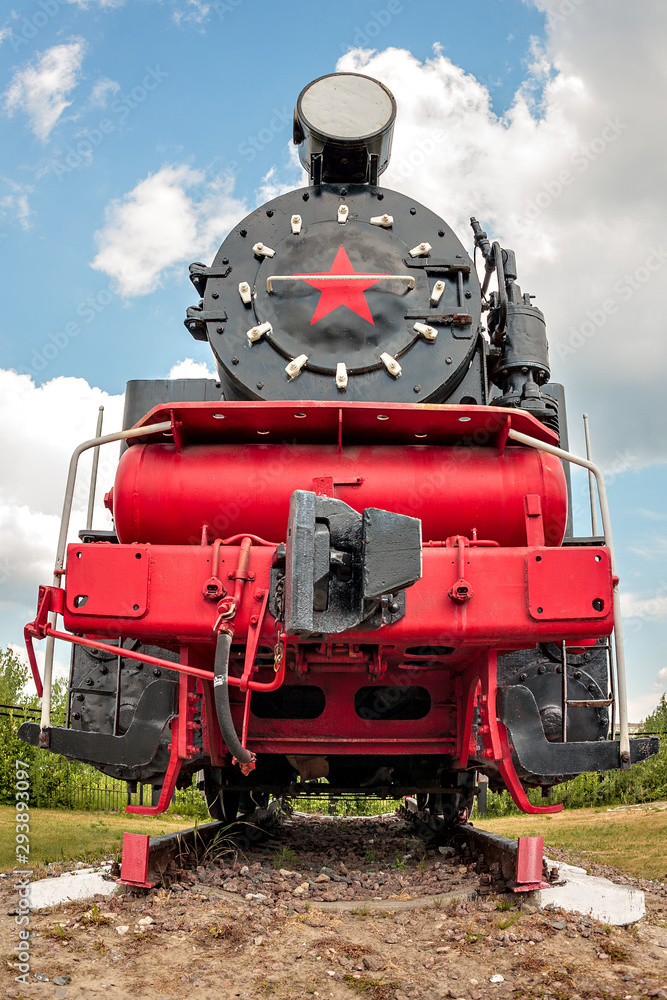 Fototapeta premium vintage steam train on the rails close-up on sky background, retro vehicle, steam engine, front view