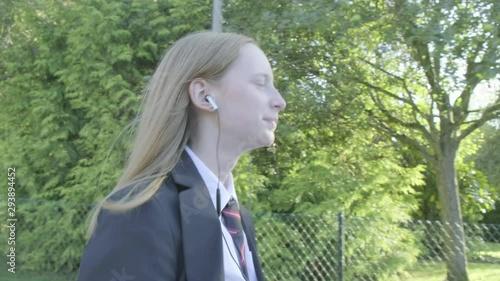 Wallpaper Mural Senior school girl walking to school listening to music themes of music technology routines education Torontodigital.ca