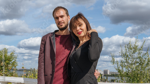 A young loving couple are posing on the waterfront in a summer day. © Anton Dios