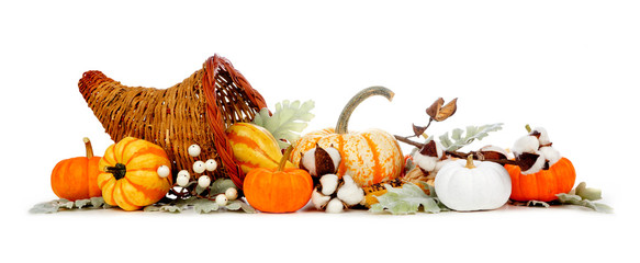 Thanksgiving cornucopia filled with autumn vegetables, pumpkins and fall decor isolated on a white background