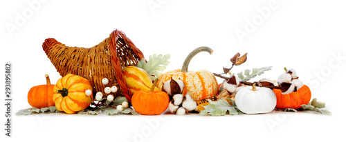 Thanksgiving cornucopia filled with autumn vegetables, pumpkins and fall decor isolated on a white background photo