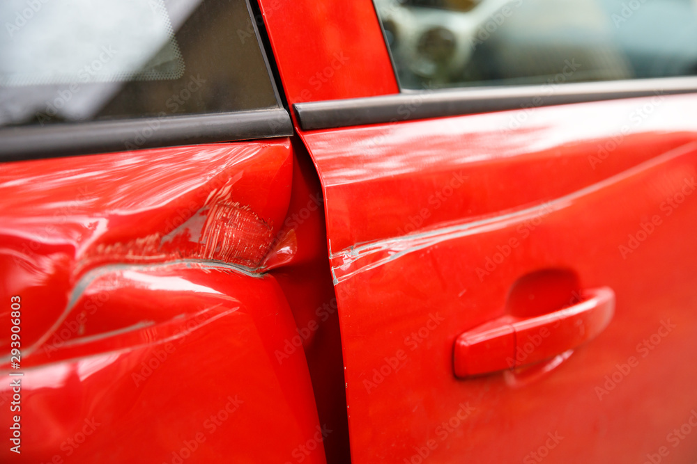 Door red car damaged in a deep dent accident, scratches on the doors. Car repair concept.  - obrazy, fototapety, plakaty 