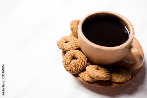 Rosquetes, a sweet made of pinol, on a traditional coffee cup made of clay.  Nicaraguan breakfast/snack. No people. photo