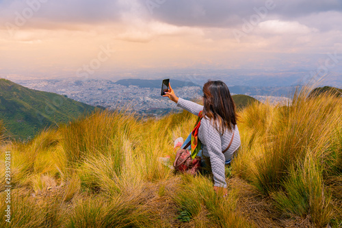 фотографія girl in the mountains sitting on cesed taking a selfie