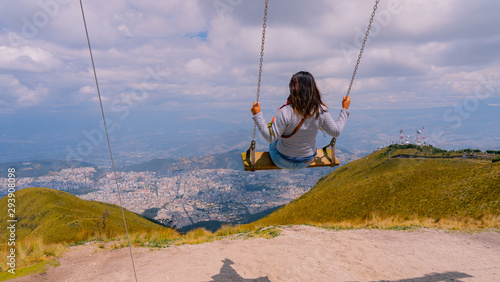  woman on swing looking at the city from the mountain