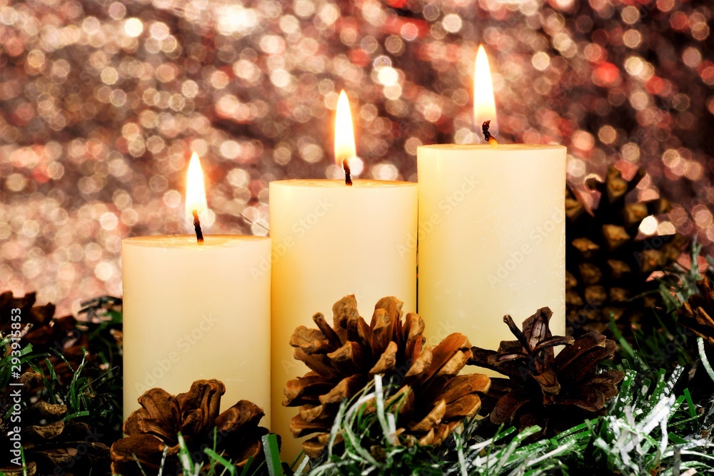 Brightly lit Christmas candles, snow-covered spruce Winter branch and cones. Candle light is a symbol of faith, hope, love, elegant creative design. Background glitter bokeh lights, New year holiday. Brightly lit Christmas candles, snow-covered spruce Winter branch and cones. Candle light is a symbol of faith, hope, love, elegant creative design. Background glitter bokeh lights, New year holiday.