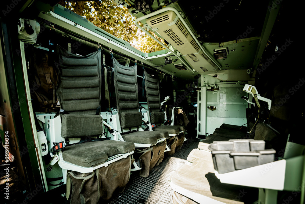 Multi-role armored military vehicle personnel carrier interior with empty chairs on both side carry up to eight infantry soldiers inside reconnaissance vehicle and equipped with remote weapons station
