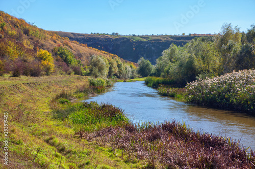 autumnal scenery with river and green hills