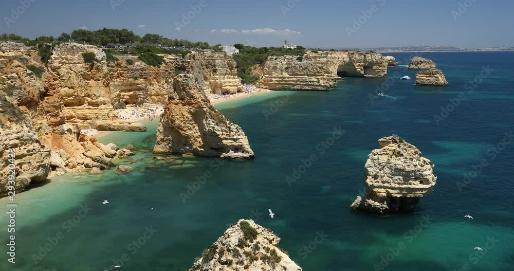 Natural caves at Marinha beach, Algarve Portugal. Rock cliff arches on Marinha beach and turquoise sea water on coast of Portugal in Algarve region. Natural caves at Marinha beach, Algarve Portugal. Rock cliff arches on Marinha beach and turquoise sea water on coast of Portugal in Algarve region.