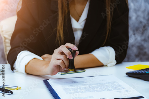 Female notary stamping document agreement at table, close up. photo