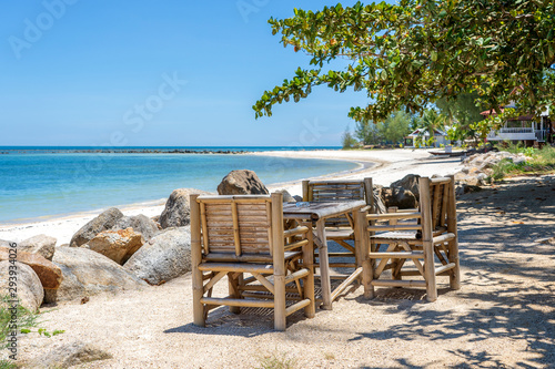 Bamboo table and chairs on tropical sand beach near blue sea water on island Koh Phangan  Thailand