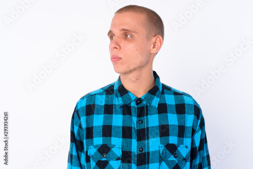 Face of young bald hipster man thinking and looking away