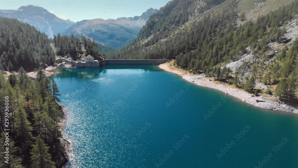 Aerial view of dam in an alpine valley, blue water reflection on the landscape. 4k Aerial view of dam in an alpine valley, blue water reflection on the landscape. 4k
