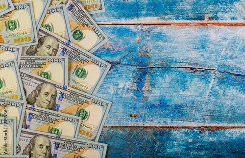100 dollars banknotes bills on blue old wooden background Money concept.