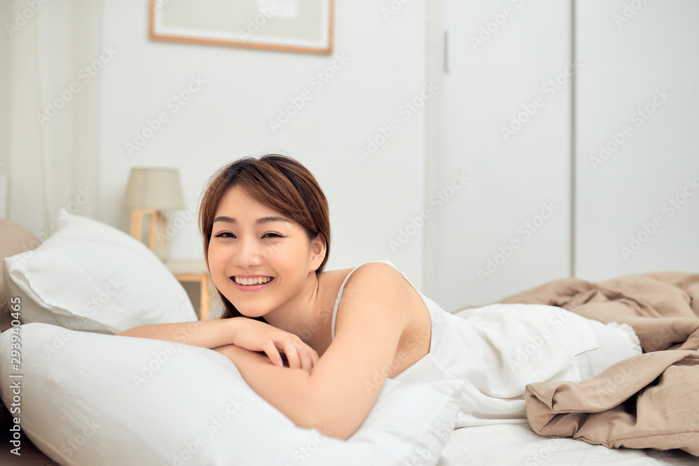Pretty young Asian woman on bed smiling after wake up Pretty young Asian woman on bed smiling after wake up