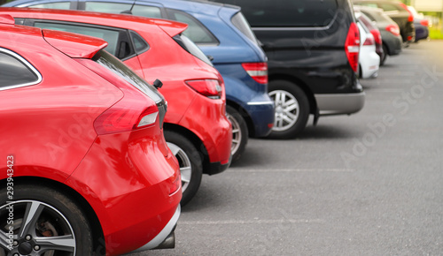Closeup of rear, back side of red car with  other cars parking in outdoor parking area. © Amphon