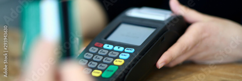 Customer paying with credit card via payment terminal at cash desk background concept