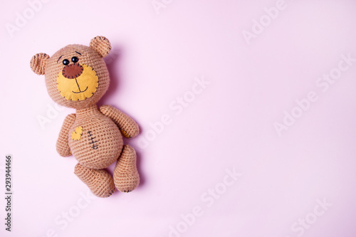 Toy teddy bear isolated on a pink background. Baby background. Copy space, top view. © KsPhoto
