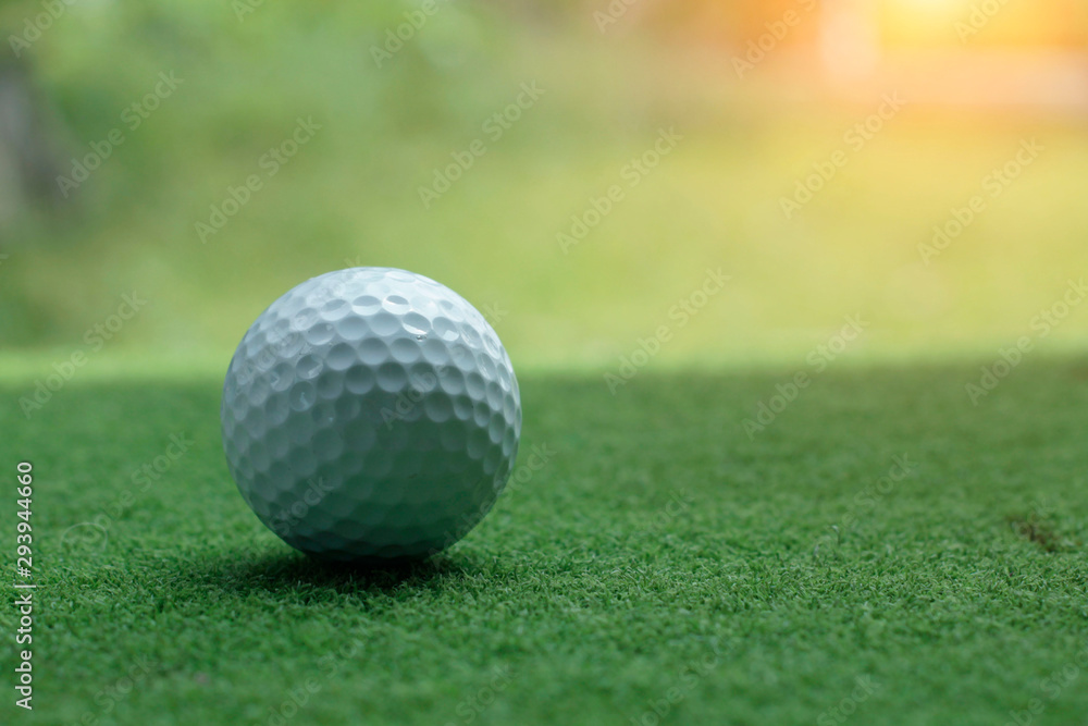 Blurred golf ball on green grass in the evening golf course Blurred golf ball on green grass in the evening golf course