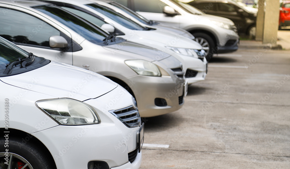 Closeup of front side of white car and other cars parking in outdoor parking area. Closeup of front side of white car and other cars parking in outdoor parking area.
