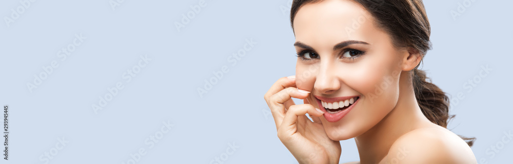 Portrait of beautiful young woman with naked shoulders, isolated against grey background, with copy space area, for some text, advertising or slogan. Brunette girl in studio picture. Portrait of beautiful young woman with naked shoulders, isolated against grey background, with copy space area, for some text, advertising or slogan. Brunette girl in studio picture.