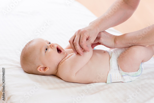 Baby massage. Massagist or therapist doing gymnastics to kid infant