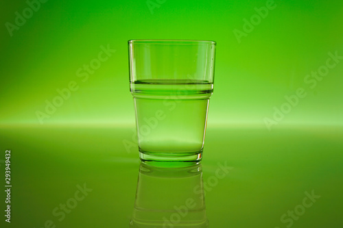 Drinking water in a glass with green background