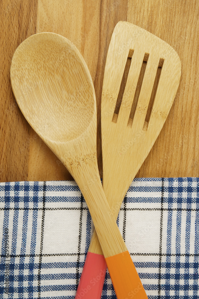 Tablecloth, spatula and spoon on wooden table background, cooking concept