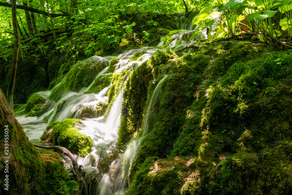 Small cascades of fresh water rushing down mossy rocks at the Plitvice Lakes National Park in Croatia
