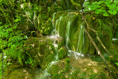 Small cascades of fresh water rushing down mossy rocks at the Plitvice Lakes National Park in Croatia
